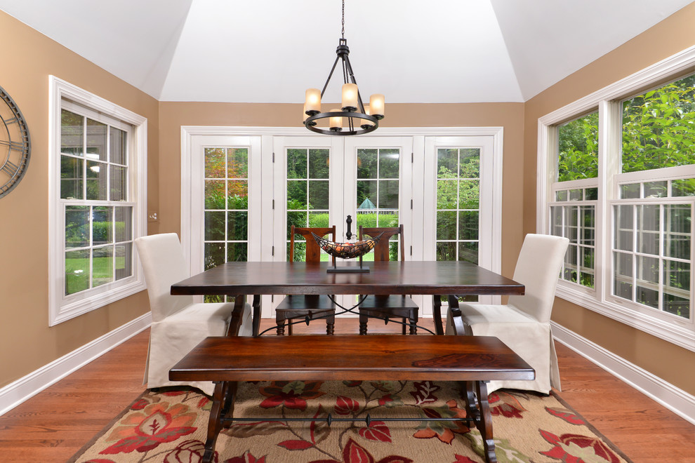 Traditional separate dining room in Cleveland with brown walls and dark hardwood floors.