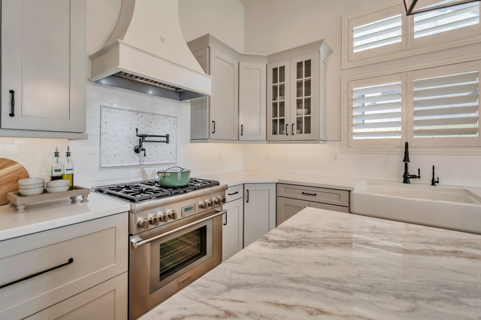 Kitchen - large transitional u-shaped porcelain tile, brown floor and exposed beam kitchen idea in Phoenix with a farmhouse sink, shaker cabinets, gray cabinets, quartzite countertops, white backsplash, porcelain backsplash, stainless steel appliances, an island and white countertops