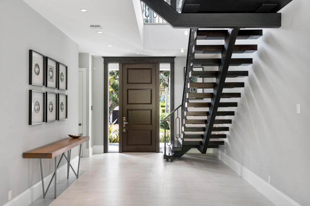 Inspiration for a large contemporary foyer in Miami with grey walls, porcelain floors, a single front door, a dark wood front door and white floor.
