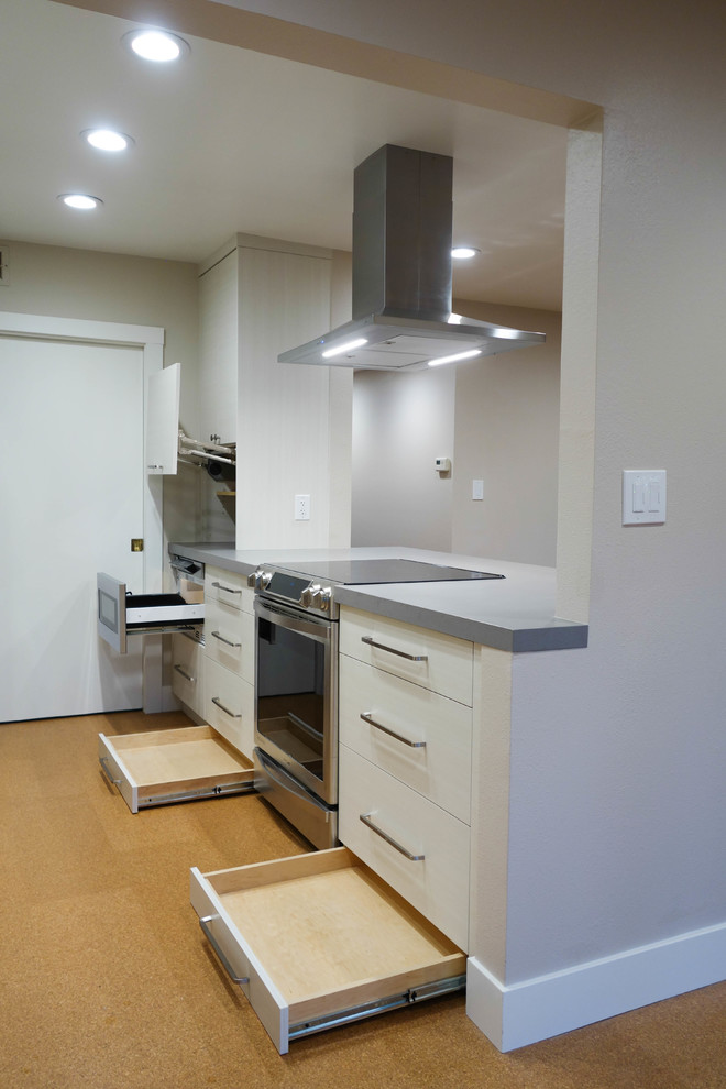 Photo of a small contemporary galley eat-in kitchen in San Francisco with a single-bowl sink, flat-panel cabinets, beige cabinets, quartz benchtops, yellow splashback, porcelain splashback, stainless steel appliances, cork floors, yellow floor and grey benchtop.
