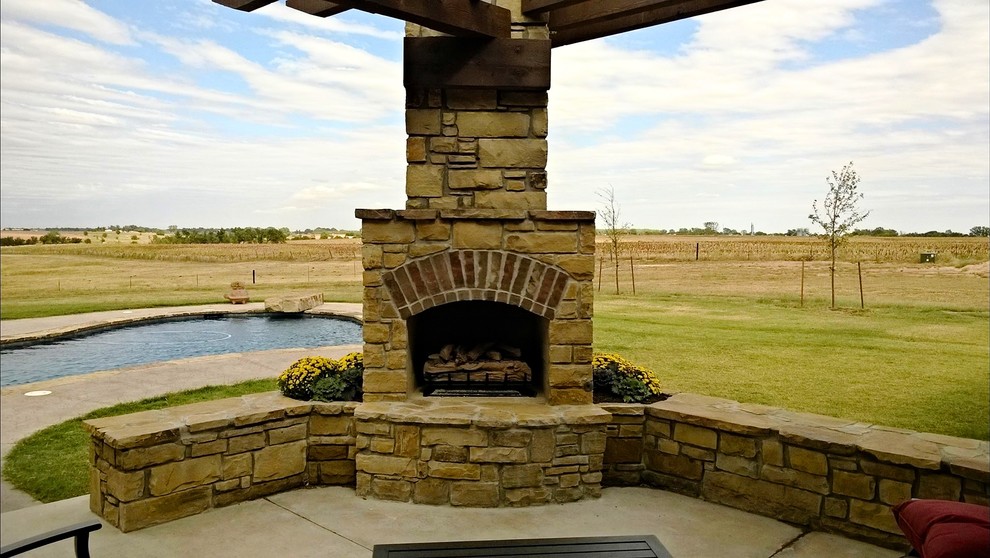 Photo of a small country backyard patio in Oklahoma City with a fire feature, concrete slab and a pergola.