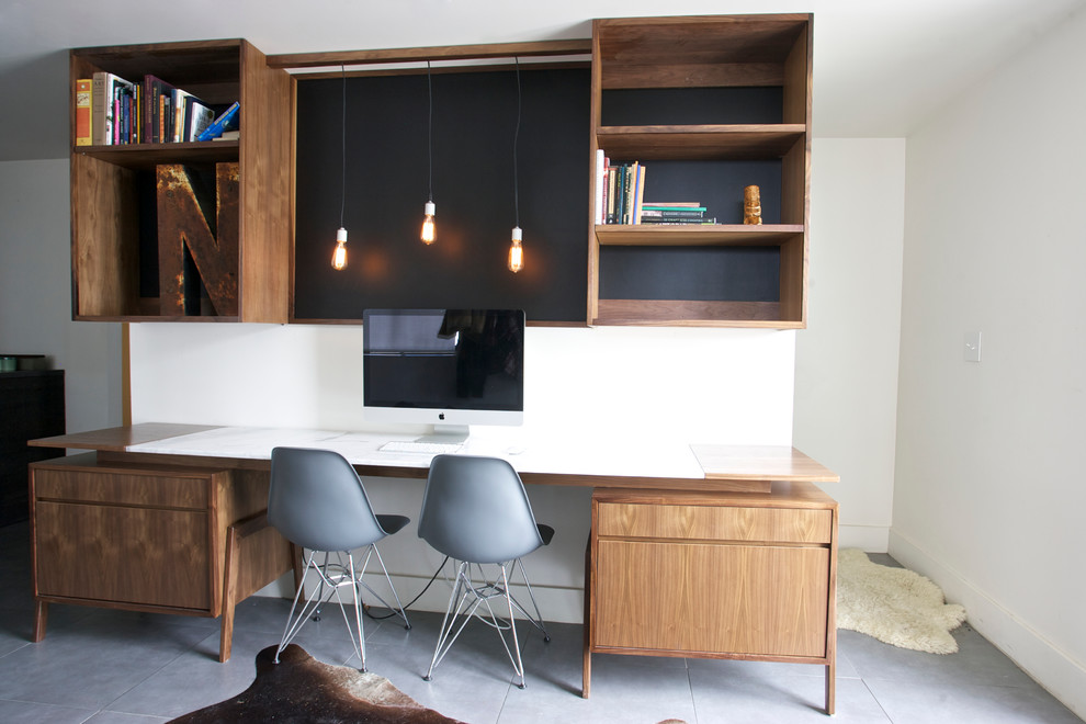 This is an example of a contemporary home office in New York with white walls.