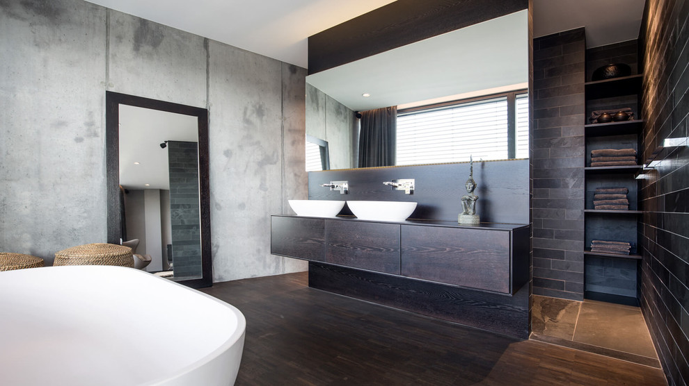 Design ideas for a large contemporary 3/4 bathroom in Dortmund with flat-panel cabinets, dark wood cabinets, a freestanding tub, brown tile, subway tile, grey walls, bamboo floors, a vessel sink, solid surface benchtops and brown floor.