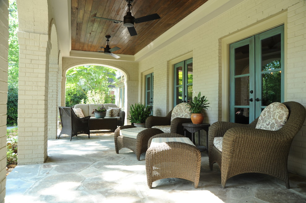 Traditional verandah in Atlanta with natural stone pavers and a roof extension.
