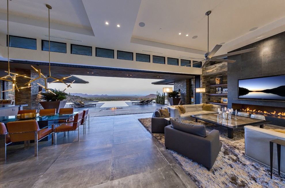 This is an example of an expansive modern open concept living room in Phoenix with a home bar, white walls, porcelain floors, a ribbon fireplace, a stone fireplace surround and a wall-mounted tv.