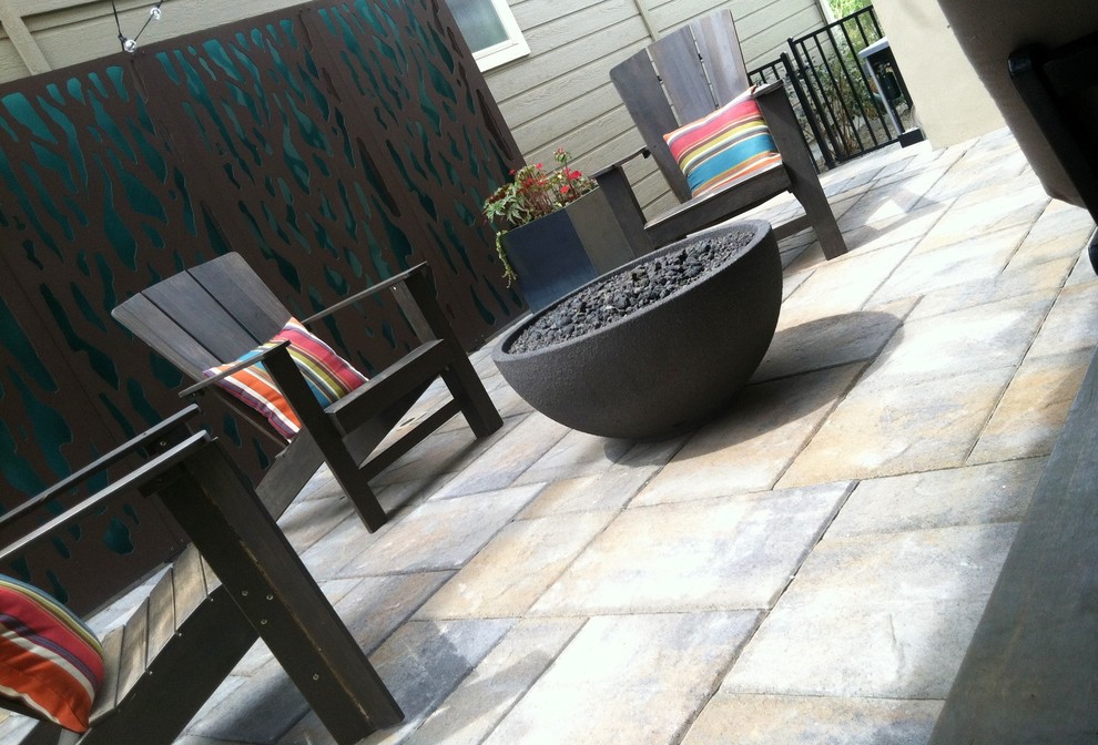 This is an example of a small modern side yard patio in Boise with a fire feature and concrete pavers.