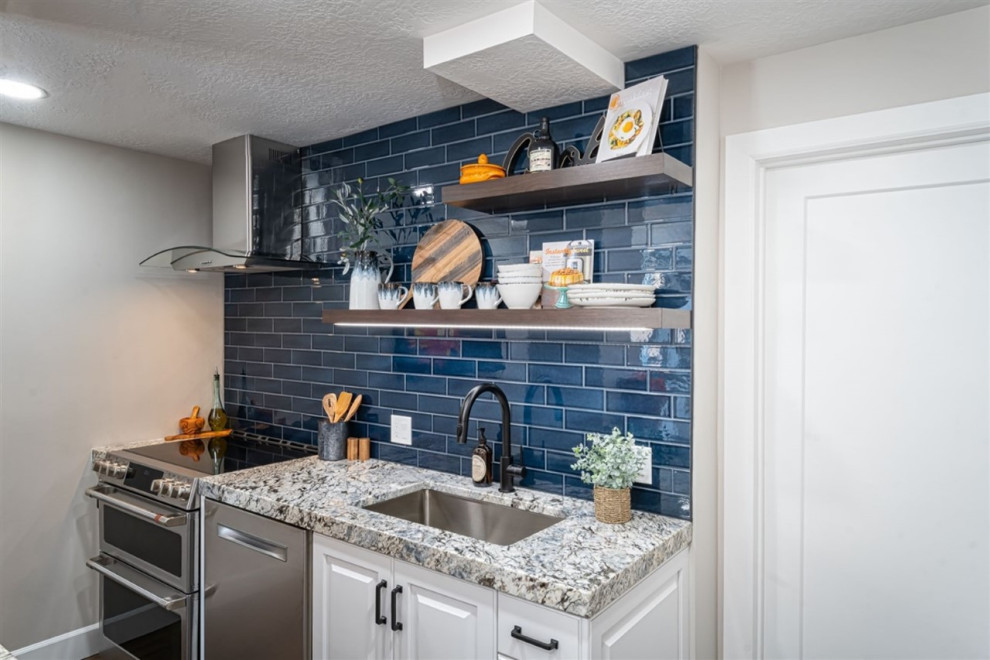 Design ideas for a mid-sized transitional u-shaped eat-in kitchen in Salt Lake City with an undermount sink, raised-panel cabinets, white cabinets, granite benchtops, blue splashback, subway tile splashback, stainless steel appliances, medium hardwood floors, with island, brown floor and blue benchtop.