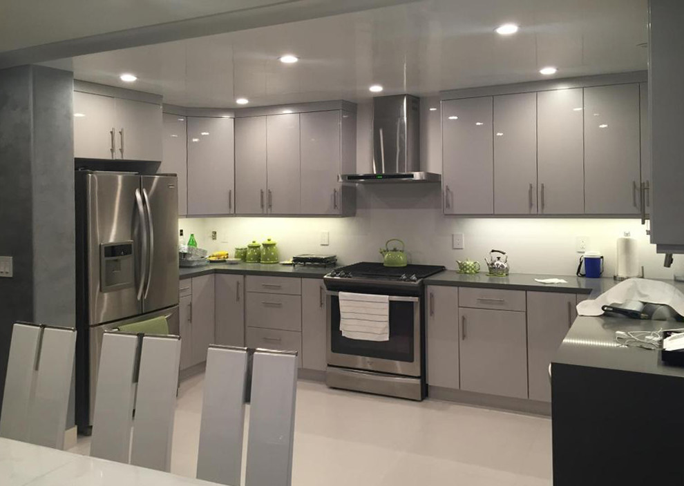 Inspiration for a mid-sized modern u-shaped eat-in kitchen in Los Angeles with a double-bowl sink, flat-panel cabinets, grey cabinets, quartz benchtops, white splashback, stainless steel appliances, no island and porcelain floors.