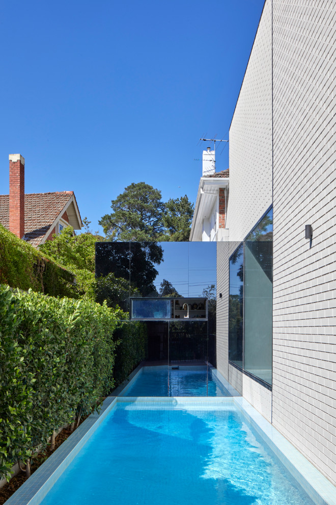 Immagine di una piscina fuori terra design rettangolare di medie dimensioni e dietro casa