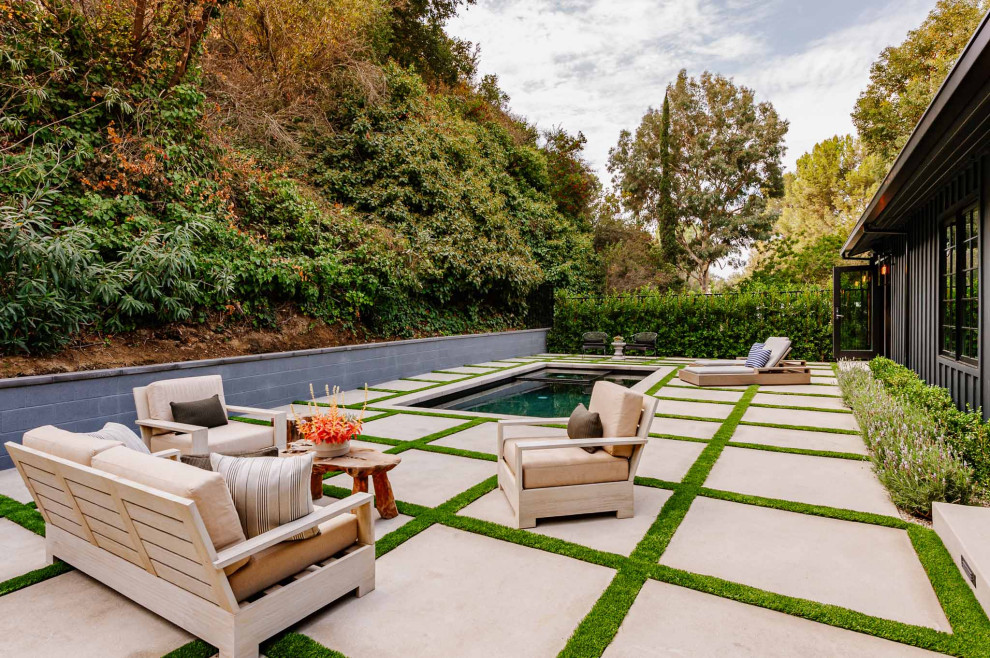 This is an example of a country backyard rectangular natural pool in Los Angeles with concrete pavers.