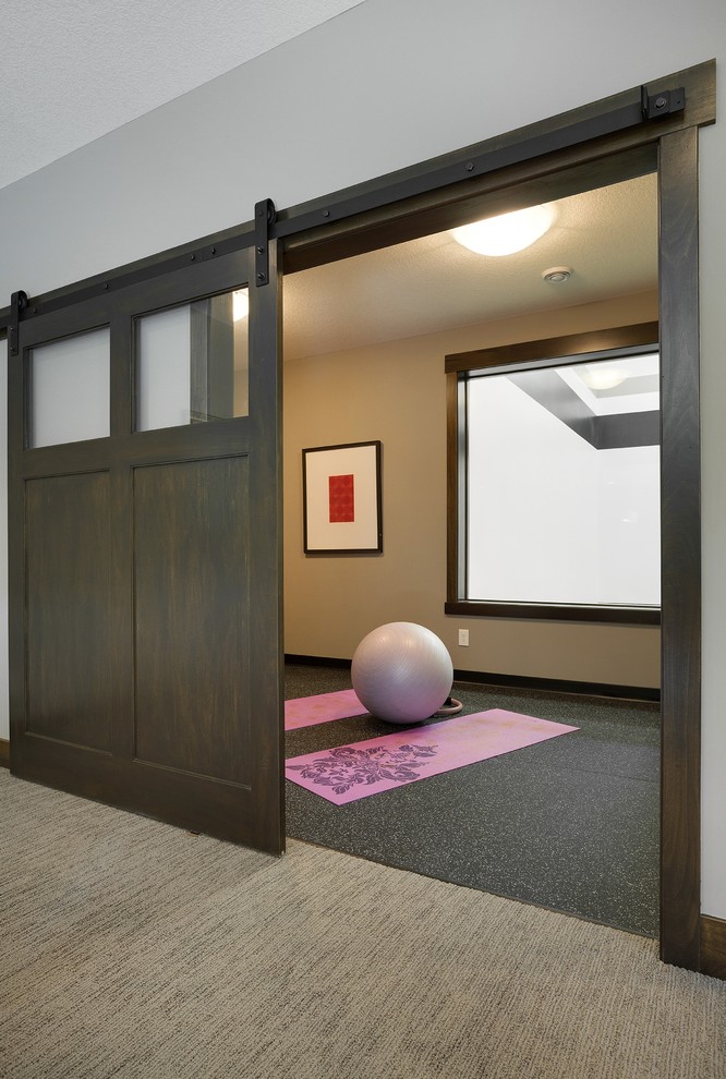 Photo of a mid-sized transitional home yoga studio in Minneapolis with beige walls, vinyl floors and black floor.