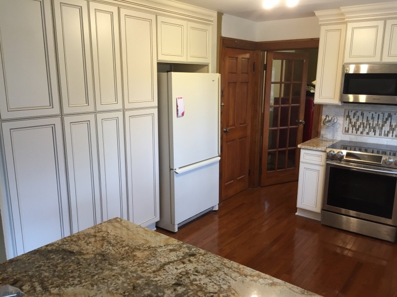 Mid-sized transitional u-shaped medium tone wood floor eat-in kitchen photo with an undermount sink, flat-panel cabinets, white cabinets, granite countertops, beige backsplash, stone tile backsplash, stainless steel appliances and a peninsula