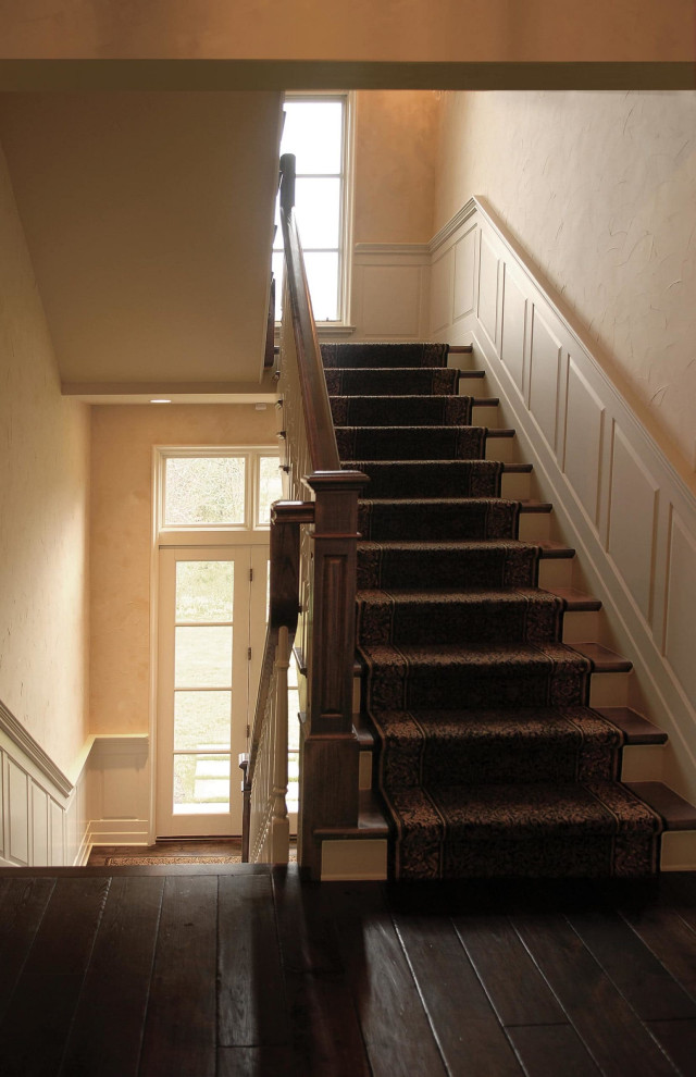Ejemplo de escalera tradicional con escalones de madera, contrahuellas de madera y barandilla de madera