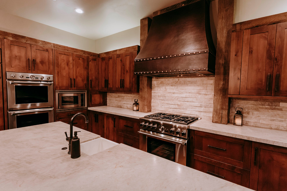 Inspiration for a large rustic kitchen remodel in Las Vegas with marble backsplash, stainless steel appliances and an island