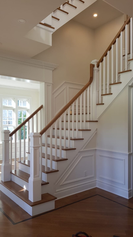 Large wood l-shaped wood railing staircase in New York with wood risers.