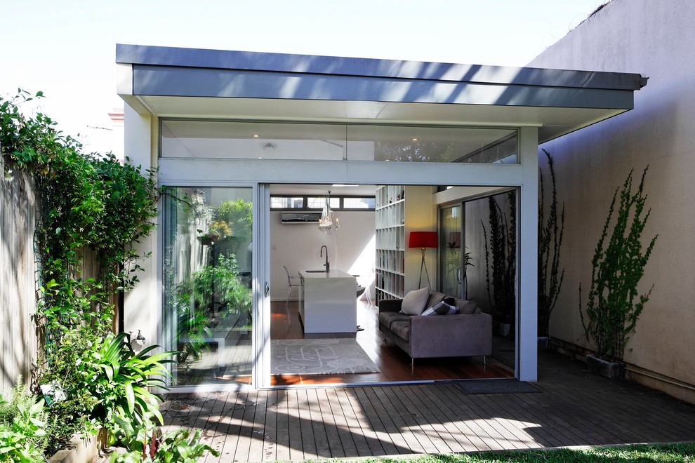 This is an example of a small contemporary backyard deck in Sydney with a roof extension.
