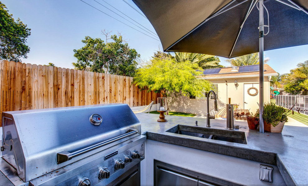 This is an example of a mid-sized transitional backyard patio in Los Angeles with an outdoor kitchen and an awning.