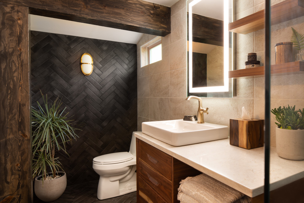 Photo of a small contemporary master bathroom in Kansas City with flat-panel cabinets, medium wood cabinets, a freestanding tub, an open shower, a one-piece toilet, beige tile, ceramic tile, black walls, ceramic floors, a vessel sink, quartzite benchtops, black floor, an open shower, white benchtops, a single vanity, a floating vanity and exposed beam.