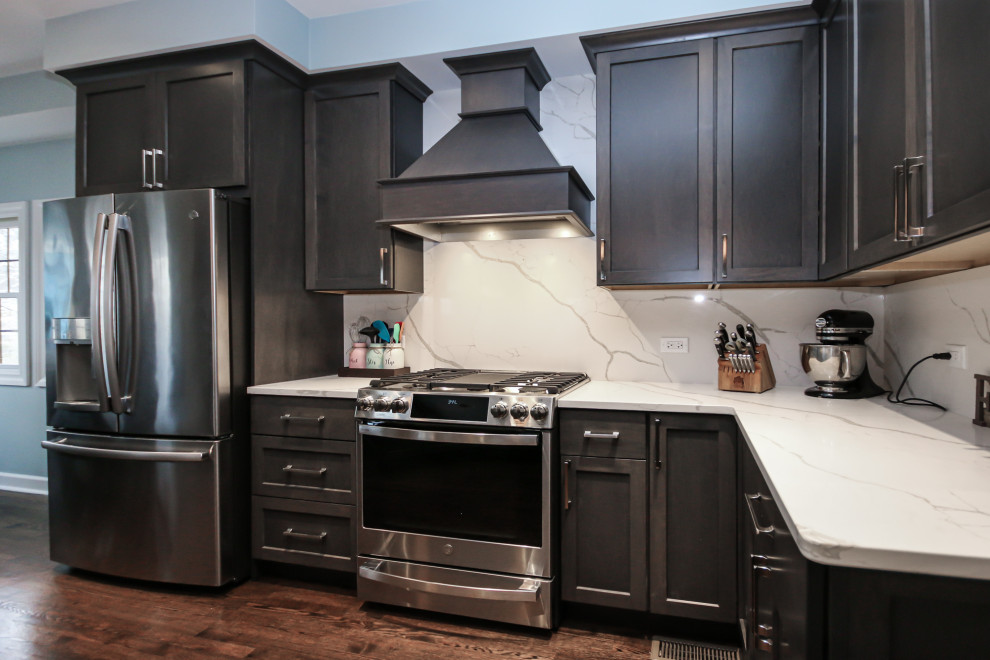 Eat-in kitchen - large transitional u-shaped medium tone wood floor eat-in kitchen idea in Chicago with a farmhouse sink, shaker cabinets, dark wood cabinets, quartz countertops, white backsplash, quartz backsplash, stainless steel appliances, a peninsula and white countertops