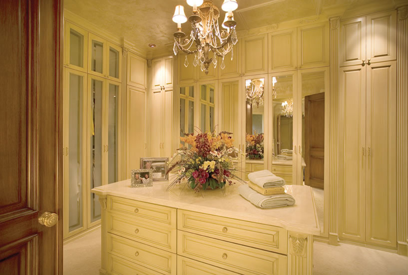 Inspiration for an expansive mediterranean women's walk-in wardrobe in Miami with beige cabinets and carpet.