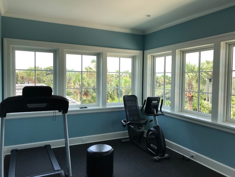 This is an example of a mid-sized traditional home gym in Atlanta with blue walls and black floor.