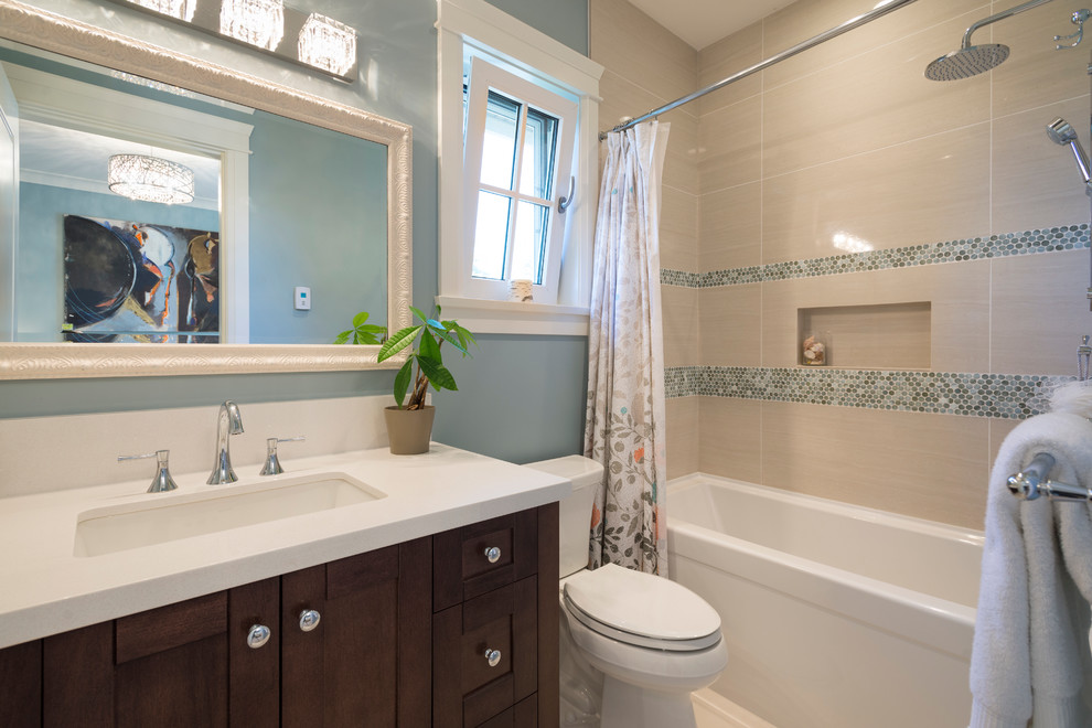 This is an example of a mid-sized transitional 3/4 bathroom in Vancouver with an undermount sink, shaker cabinets, dark wood cabinets, engineered quartz benchtops, an alcove tub, a corner shower, a two-piece toilet, gray tile, porcelain tile, blue walls and porcelain floors.