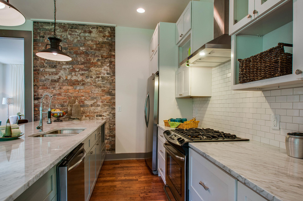 Design ideas for a mid-sized eclectic galley eat-in kitchen in Nashville with shaker cabinets, grey cabinets, granite benchtops, white splashback, ceramic splashback, stainless steel appliances and with island.