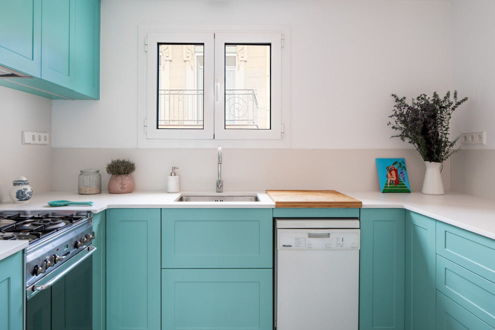 This is an example of a mid-sized modern u-shaped separate kitchen in Barcelona with an undermount sink, raised-panel cabinets, turquoise cabinets, quartz benchtops, white splashback, engineered quartz splashback, stainless steel appliances, porcelain floors, grey floor and white benchtop.
