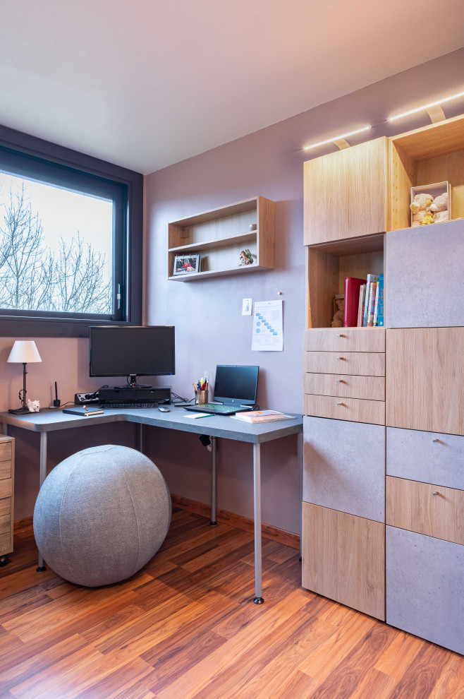 Idee per un ufficio design di medie dimensioni con pareti viola, pavimento in legno massello medio, nessun camino, scrivania autoportante e pavimento marrone