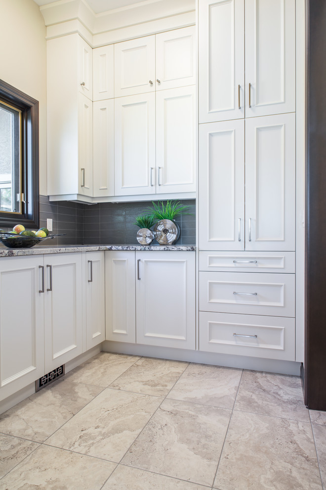 Design ideas for a large traditional l-shaped eat-in kitchen in Calgary with beaded inset cabinets, white cabinets, granite benchtops, beige splashback, glass tile splashback, panelled appliances, an undermount sink, with island and medium hardwood floors.