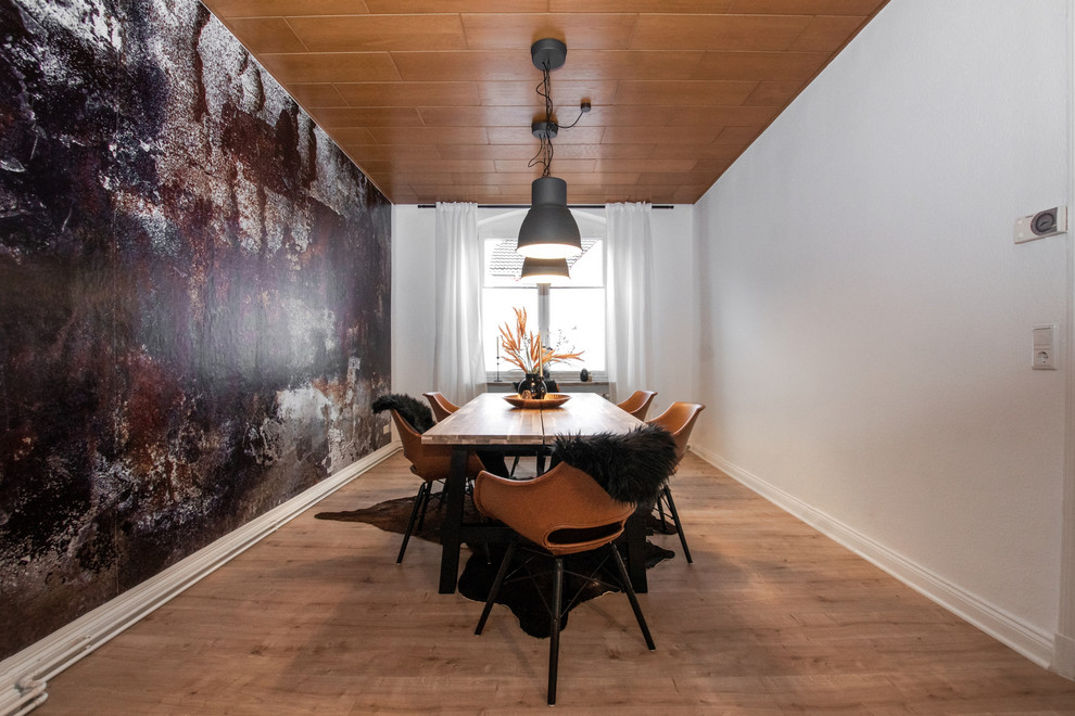 Mittelgroßes Industrial Esszimmer mit weißer Wandfarbe und braunem Holzboden in Köln