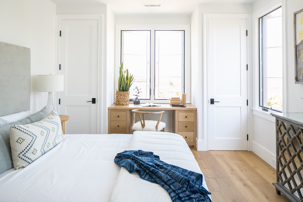 Inspiration for a transitional bedroom in Orange County with white walls, medium hardwood floors and brown floor.