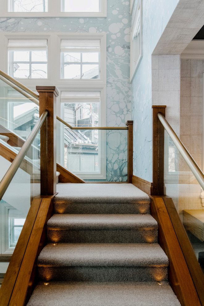 Design ideas for a mid-sized country carpeted l-shaped staircase in Salt Lake City with glass railing, wallpaper and carpet risers.