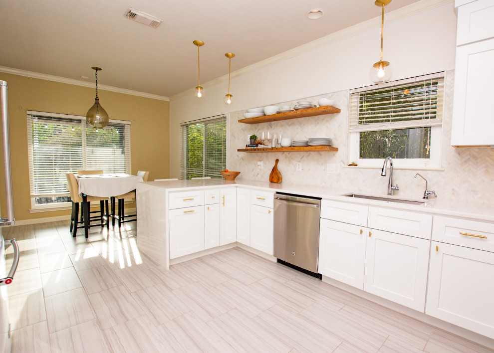 Transitional porcelain tile and gray floor eat-in kitchen photo in Austin with an undermount sink, shaker cabinets, white cabinets, quartz countertops, white backsplash, marble backsplash, stainless steel appliances, a peninsula and white countertops