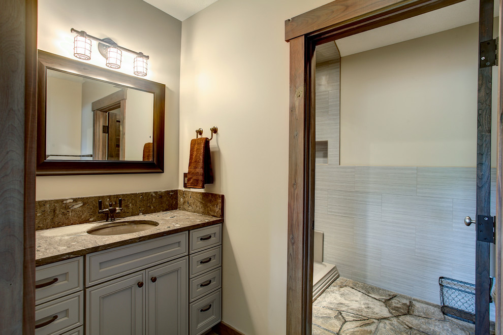 Mid-sized arts and crafts kids bathroom in Grand Rapids with an undermount sink, shaker cabinets, blue cabinets, granite benchtops, an open shower, a two-piece toilet, gray tile, subway tile, beige walls and ceramic floors.