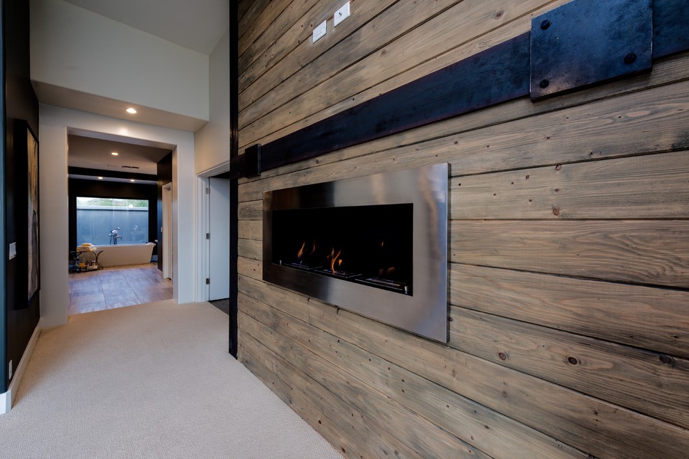 This is an example of an expansive transitional master bedroom in Phoenix with grey walls, carpet, a hanging fireplace, a metal fireplace surround and beige floor.