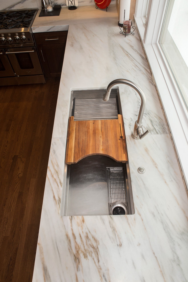 Enclosed kitchen - huge transitional l-shaped medium tone wood floor enclosed kitchen idea in Chicago with an undermount sink, flat-panel cabinets, medium tone wood cabinets, marble countertops, white backsplash, stone slab backsplash, stainless steel appliances and an island