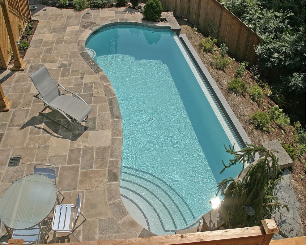 Design ideas for a small contemporary backyard custom-shaped infinity pool in Toronto with natural stone pavers.