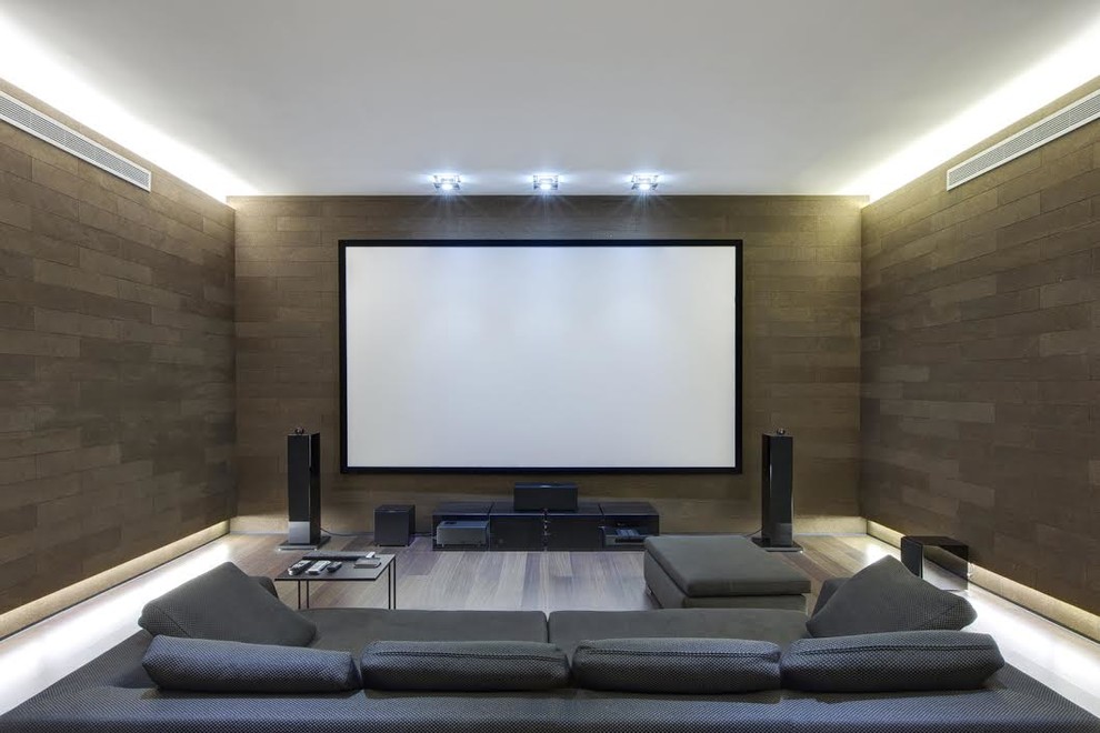 Inspiration for a mid-sized transitional open concept home theatre in Denver with white walls, dark hardwood floors, a wall-mounted tv and grey floor.