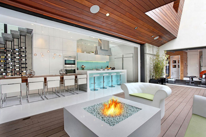 Design ideas for a contemporary backyard patio in Los Angeles with a fire feature, decking and a roof extension.