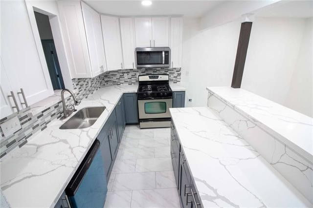Mid-sized transitional galley eat-in kitchen photo in Austin with recessed-panel cabinets, blue cabinets, quartz countertops, an island and white countertops