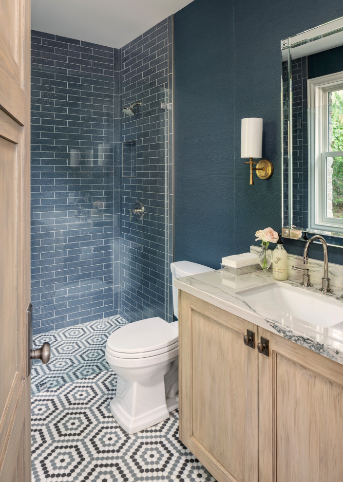Photo of a mid-sized transitional 3/4 bathroom in Salt Lake City with recessed-panel cabinets, light wood cabinets, an alcove shower, blue walls, mosaic tile floors, an undermount sink, multi-coloured floor, beige benchtops, marble benchtops and a hinged shower door.