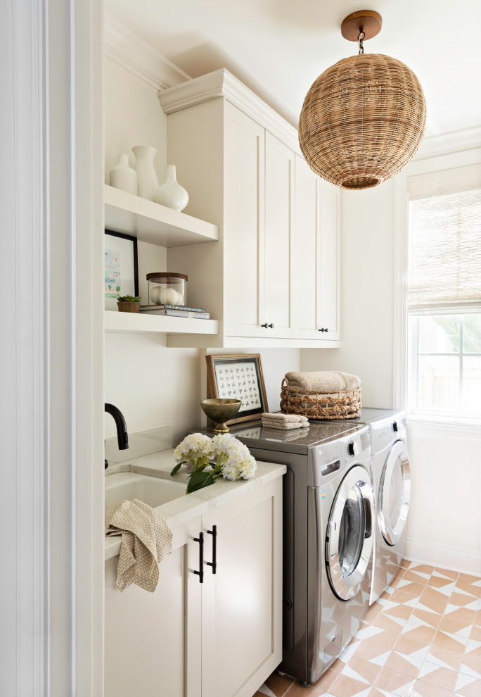 This is an example of a small transitional single-wall dedicated laundry room in Orlando with an undermount sink, shaker cabinets, white cabinets, white walls, ceramic floors, orange floor, white benchtop and a side-by-side washer and dryer.