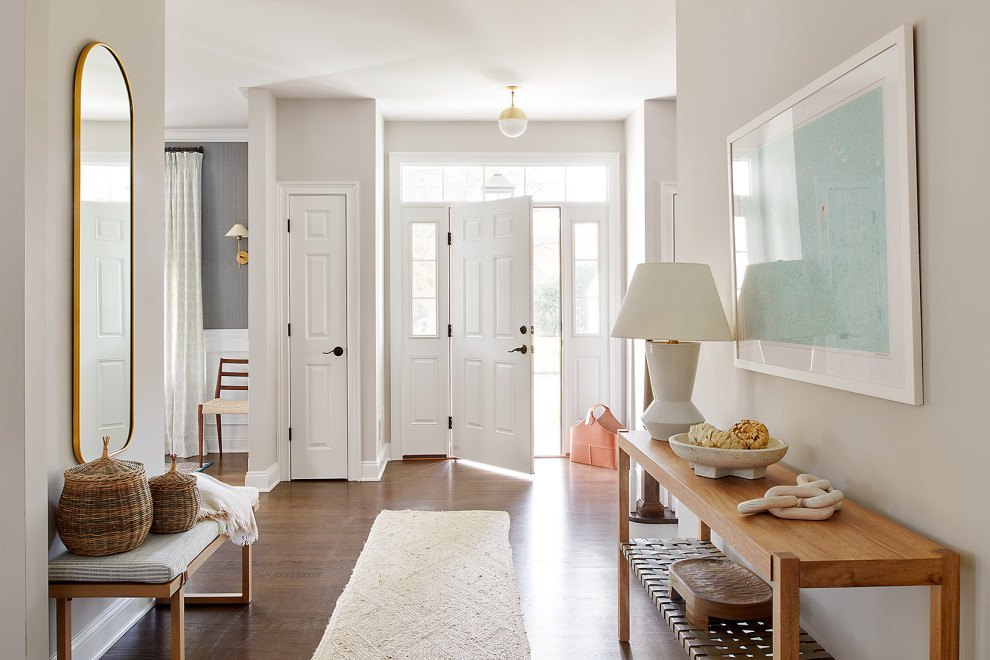 Design ideas for a beach style hallway in New York with beige walls, dark hardwood flooring, a single front door and a white front door.