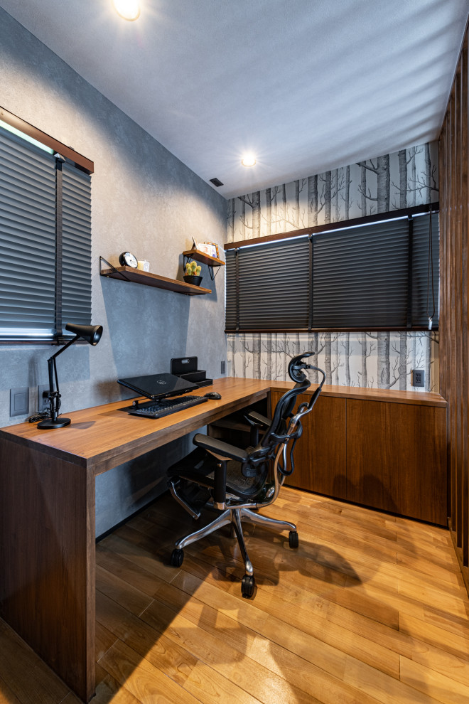 Kleines Modernes Arbeitszimmer ohne Kamin mit Arbeitsplatz, grauer Wandfarbe, dunklem Holzboden, Einbau-Schreibtisch, braunem Boden, Tapetendecke und Tapetenwänden in Fukuoka