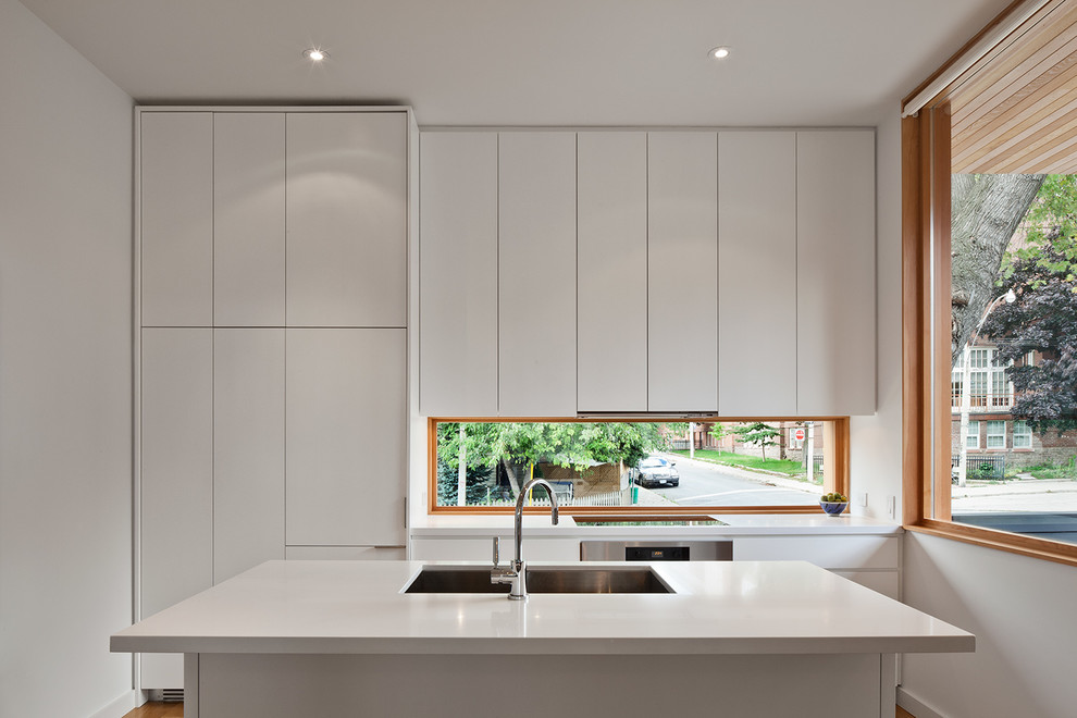 Inspiration for a small modern single-wall medium tone wood floor open concept kitchen remodel in Toronto with an undermount sink, flat-panel cabinets, white cabinets, quartz countertops, paneled appliances and an island