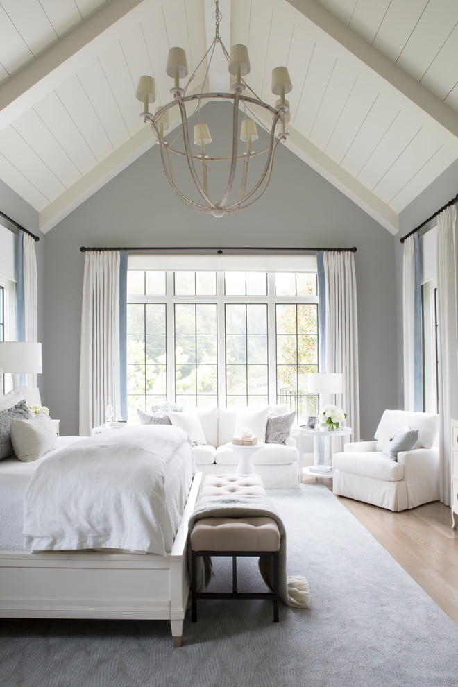 Photo of a transitional bedroom in Nashville with blue walls and light hardwood floors.