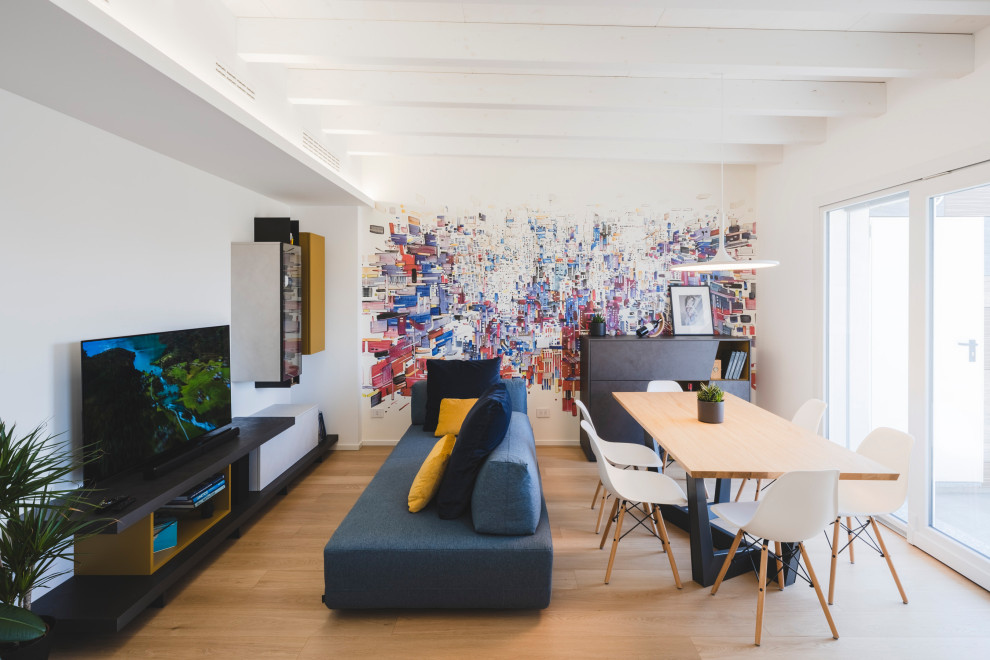 Foto på ett mellanstort skandinaviskt allrum med öppen planlösning, med flerfärgade väggar, ljust trägolv, en fristående TV och beiget golv
