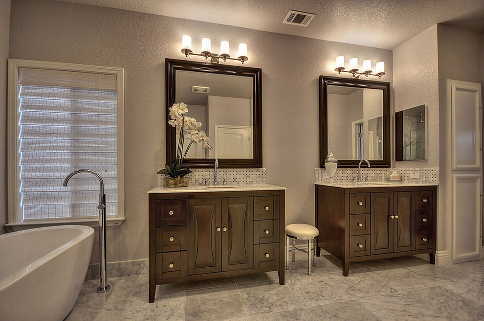 Photo of a large transitional master bathroom in Sacramento with furniture-like cabinets, dark wood cabinets, a freestanding tub, ceramic tile, marble floors, an undermount sink, granite benchtops, a corner shower, black and white tile, gray tile, multi-coloured tile, white tile and grey walls.