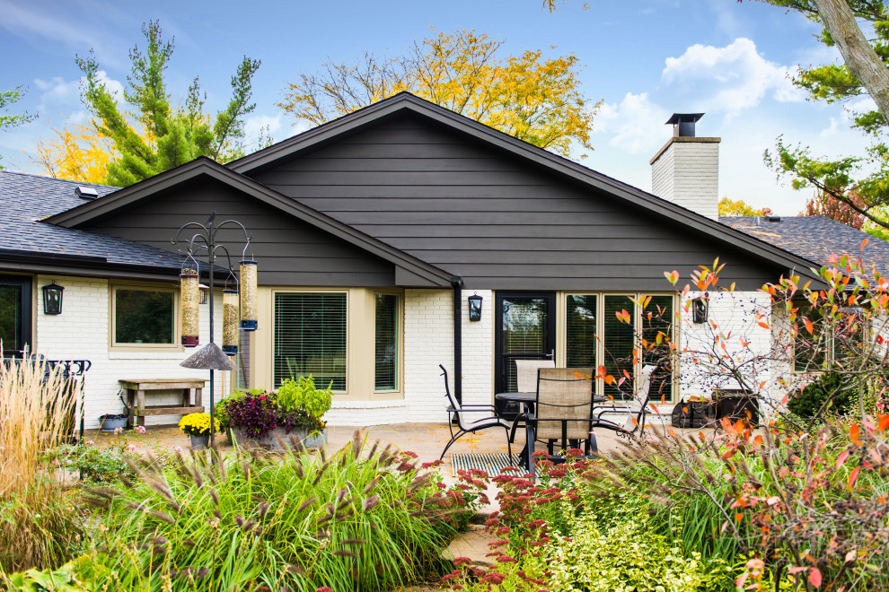 Example of a large classic white brick house exterior design in Chicago with a shingle roof